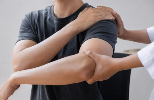 en naprapat undersöker en axel för att se vad som är felet och se om man har impingement i axeln